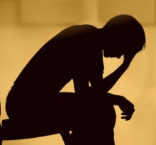 Illustrated silhouette of a man sitting with his head in his hand